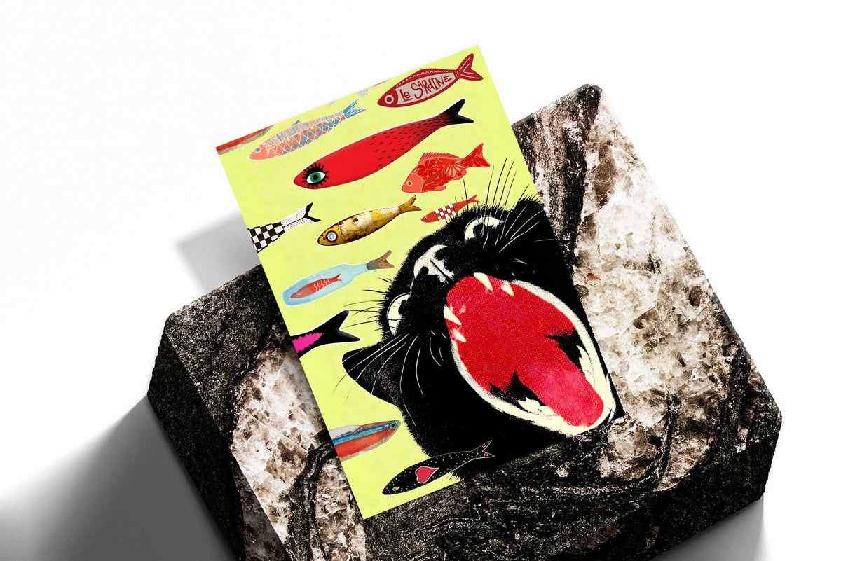Yellow cat-and-fish print poster placed on a textured black-and-gray surface