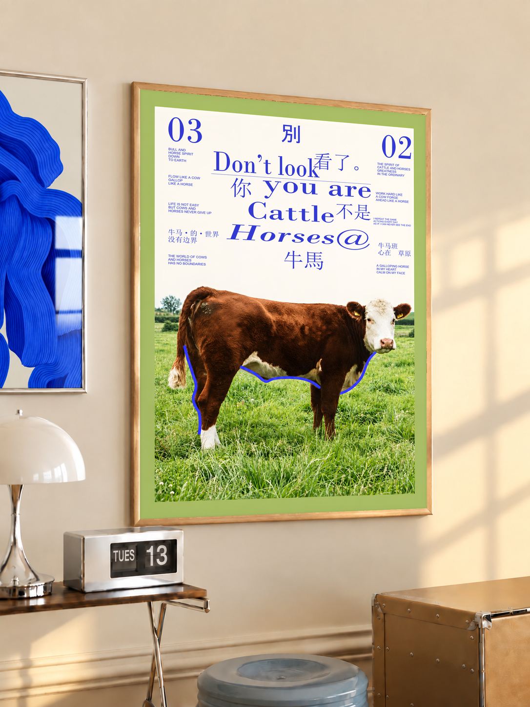 Brown and white cow in a pasture with purple lettering and lime green border; oak framed print in a desk setting