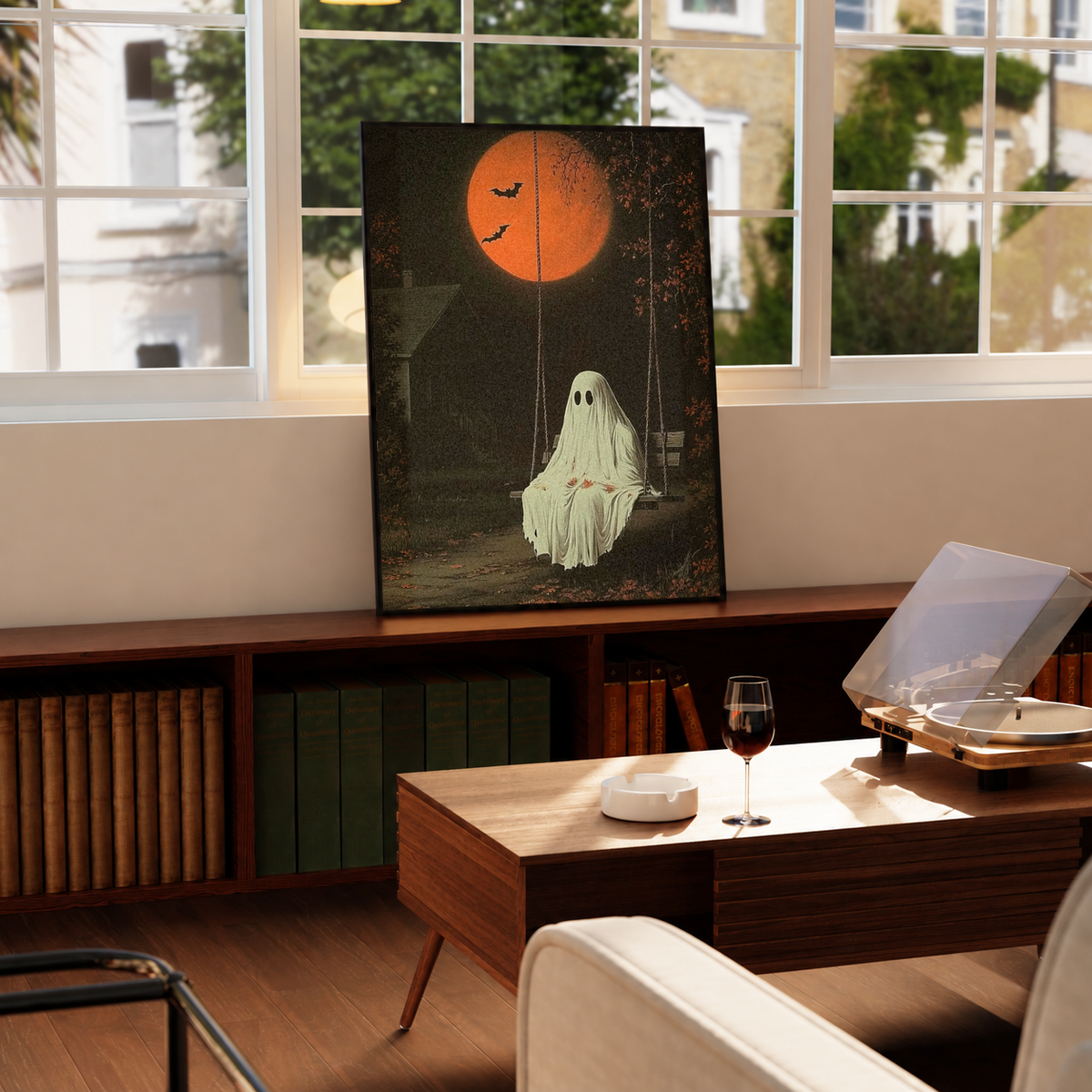 Framed ghost swing art print on display, orange moon and flying bats over a ghost