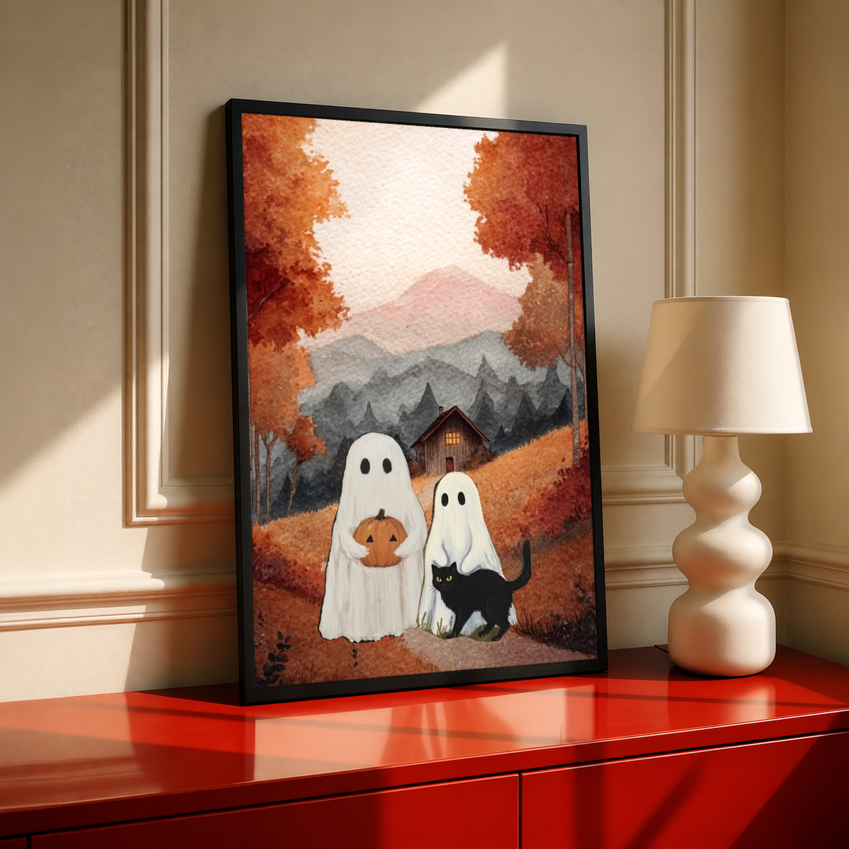 Black-framed ghost and black cat art print with pumpkin in autumn mountain cottage scene