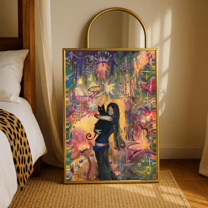 A girl embracing a black cat amid colorful ornamental flowers and patterns in a gold-tone styling frame leaning beside a bedroom mirror