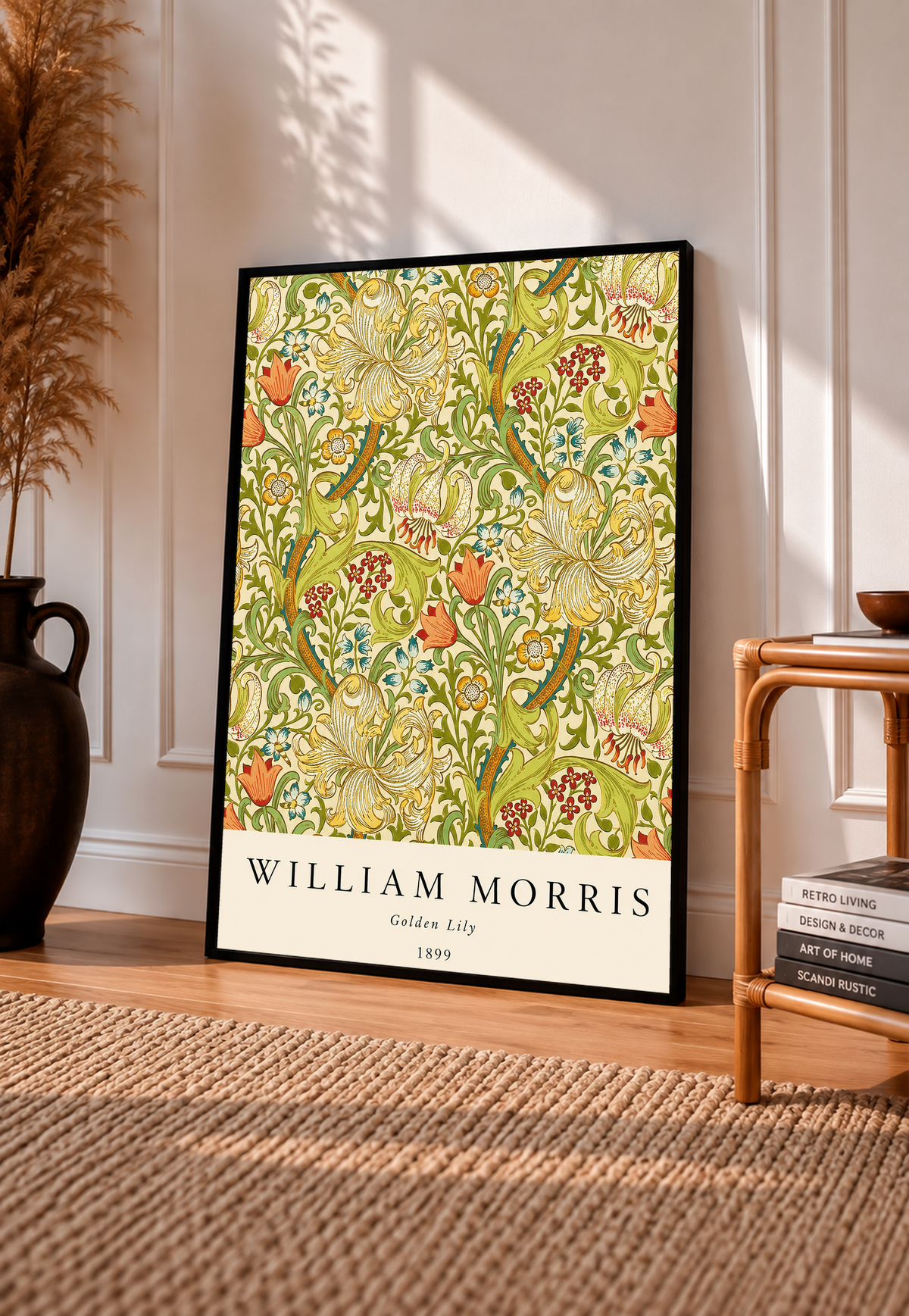 Golden Lily floral pattern with olive leaves, yellow flowers and red accents in a black frame leaning on a pale panelled wall beside a rattan chair