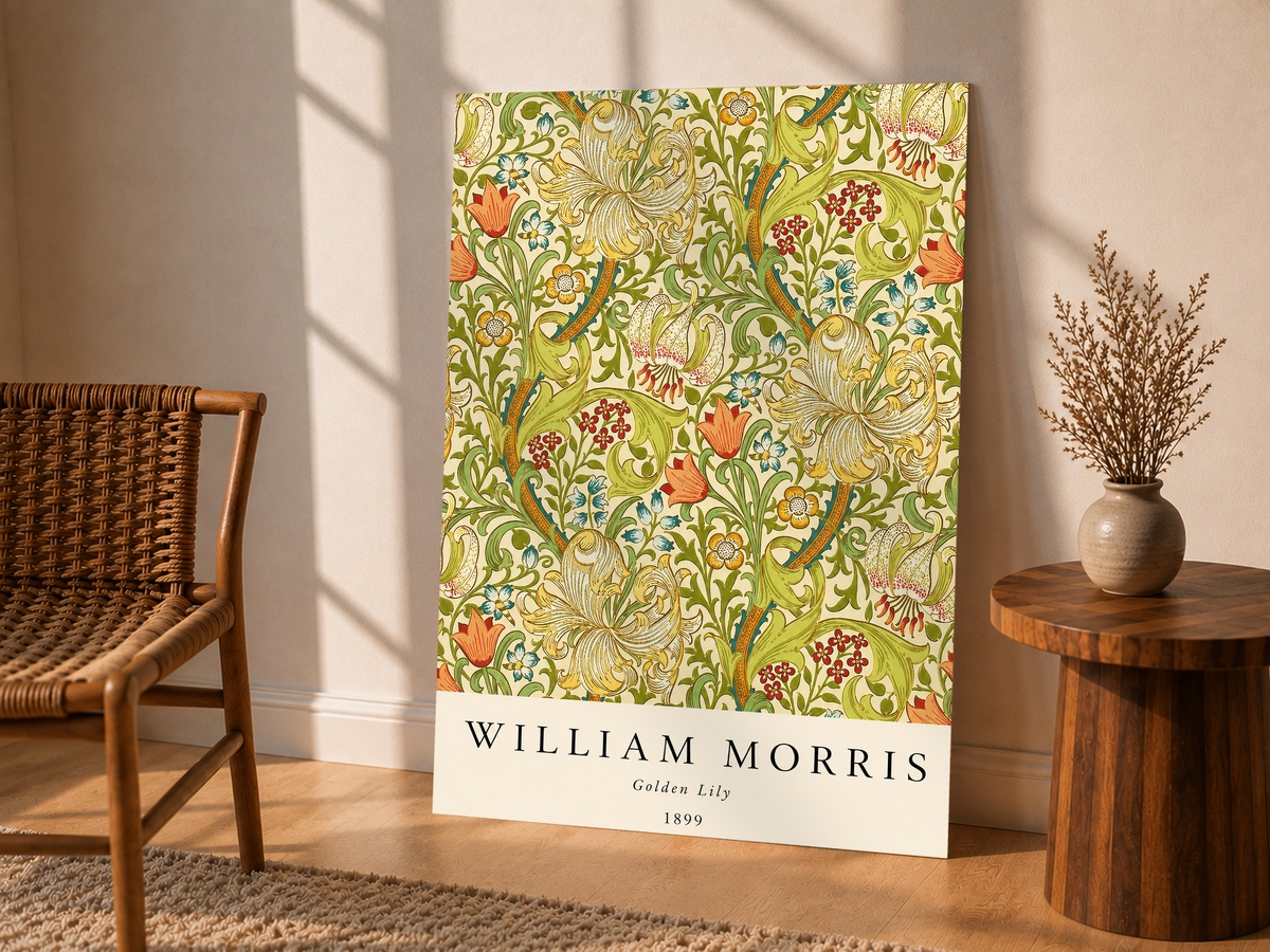 Golden Lily floral pattern with olive leaves, yellow flowers and red accents as an unframed display leaning beside a wicker chair and side table