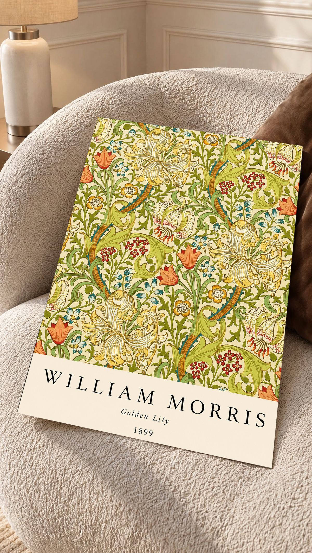 Golden Lily floral pattern with olive leaves, yellow flowers and red accents as an unframed print resting on a boucle chair