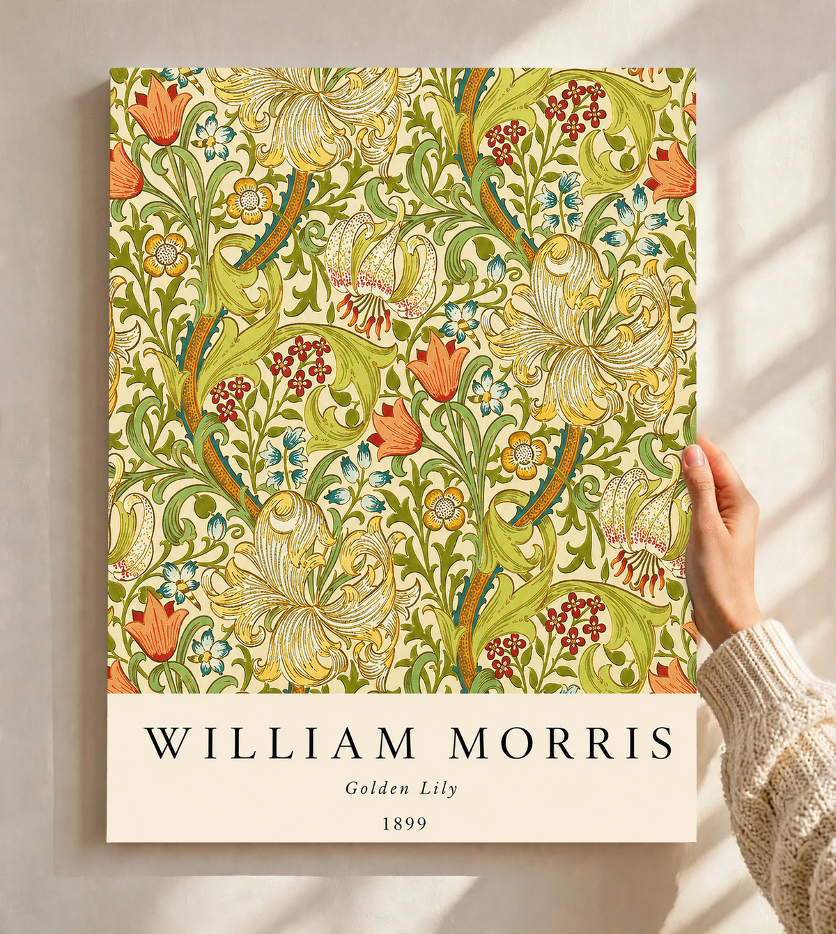 Golden Lily floral pattern with olive leaves, yellow flowers and red accents as an unframed print held against a pale wall in a close view