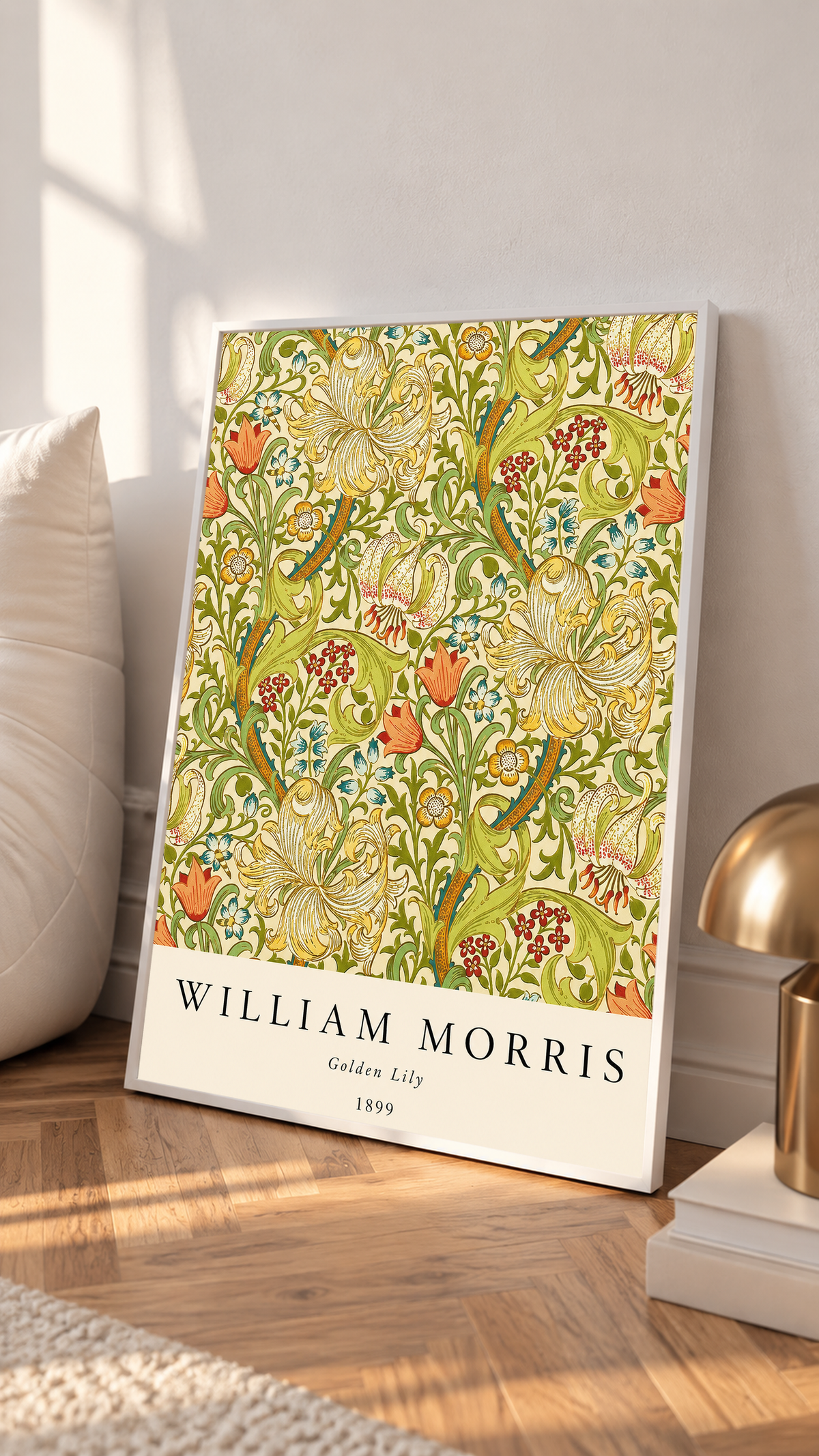 Golden Lily floral pattern with olive leaves, yellow flowers and red accents in a white frame leaning on a sunlit floor beside a brass lamp