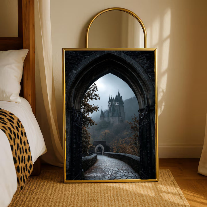 A distant gothic castle seen through a pointed stone arch above a cobbled path in a gold-tone styling frame leaning beside a bedroom mirror