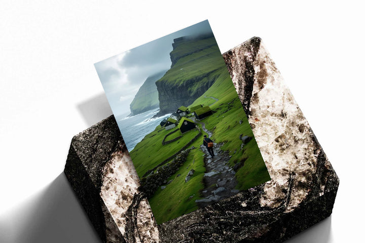 Landscape print with green cliffs, seaside village houses, and a hiker on a rocky path