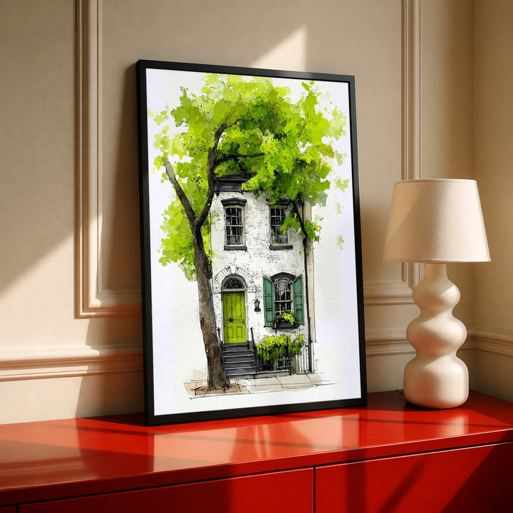 Framed watercolor townhouse print with leafy green tree and bright green door