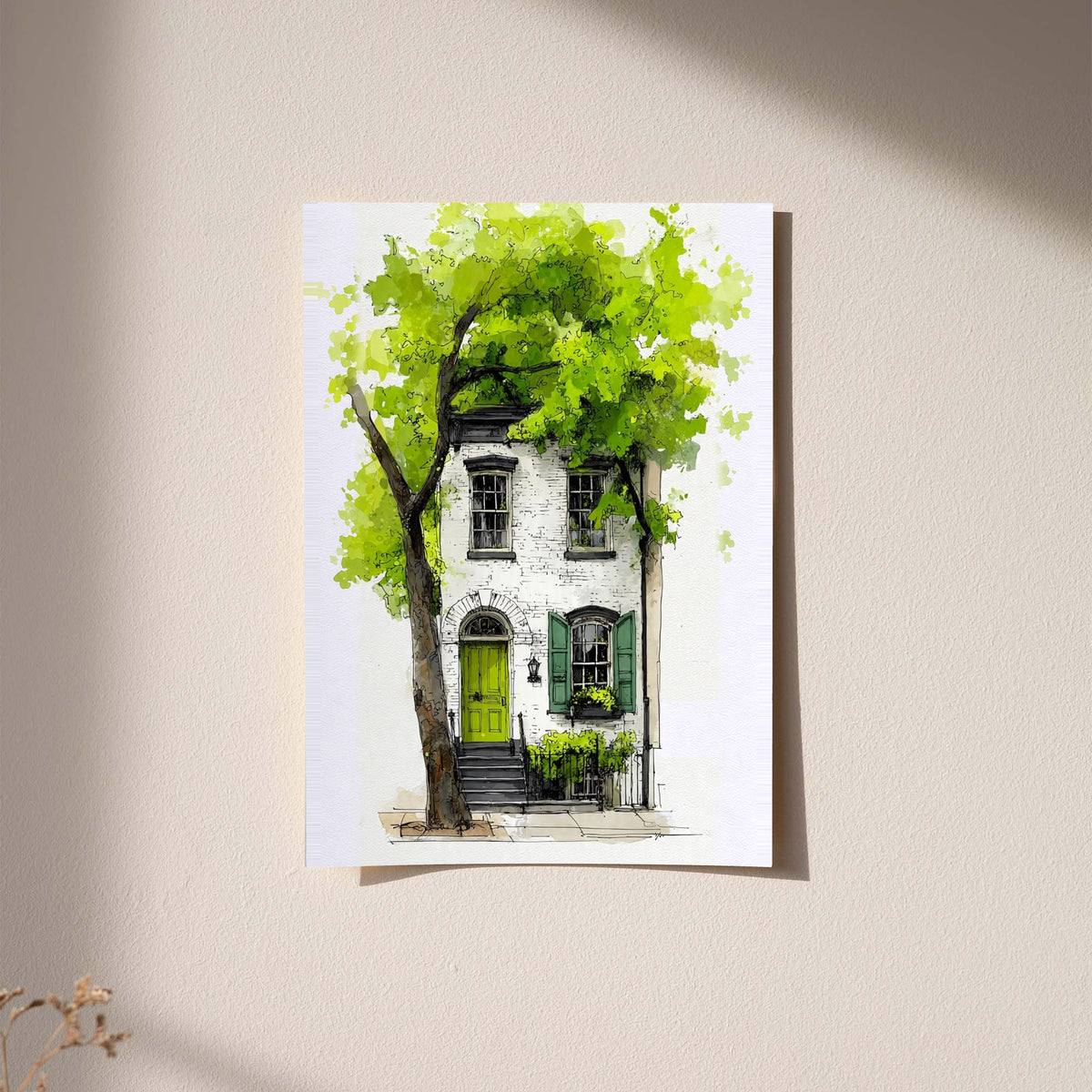 Framed watercolor townhouse print on light wall with leafy tree and green door