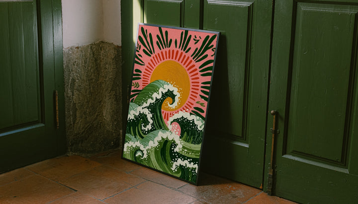 Curling green waves with cream foam beneath an orange sun on a pink background leaning on the floor against dark green wall panelling