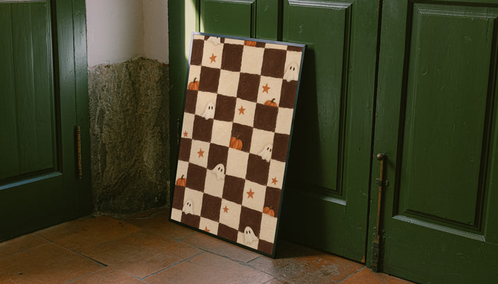 Brown and cream Halloween checkerboard with little white ghosts, pumpkins and orange stars leaning on the floor against dark green wall panelling