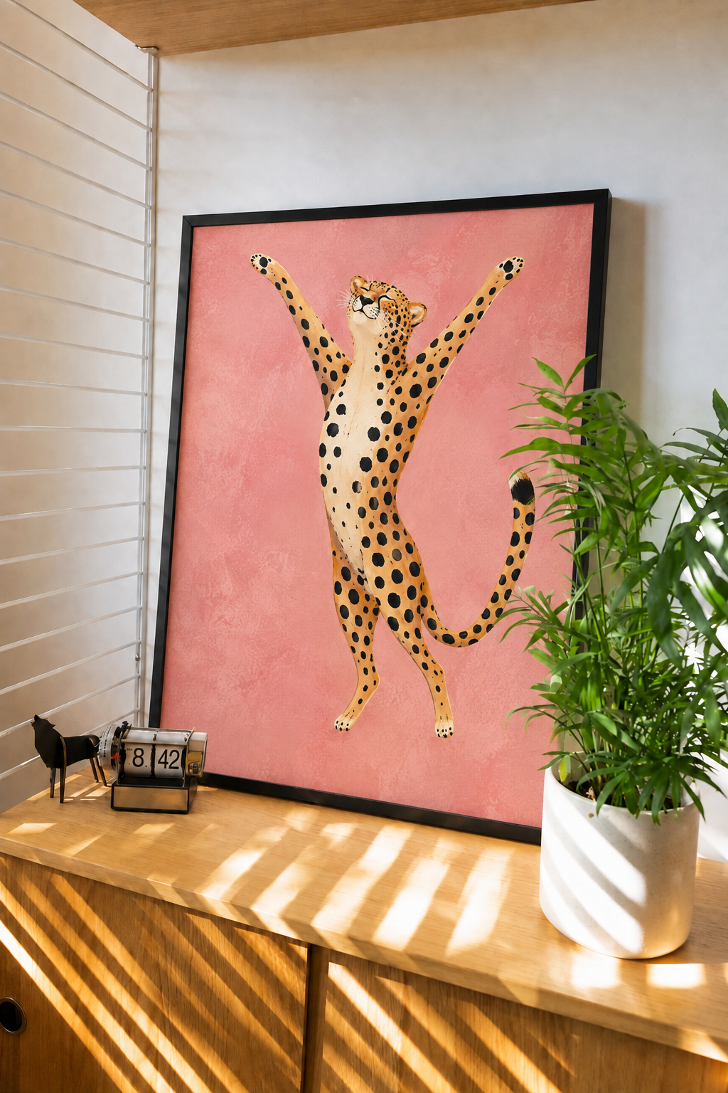 Framed cheetah wall art print with pink background, black frame, cat illustration