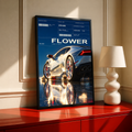 Silver Huracan with flowers around the rear wheel and night reflections; black framed print on a red cabinet