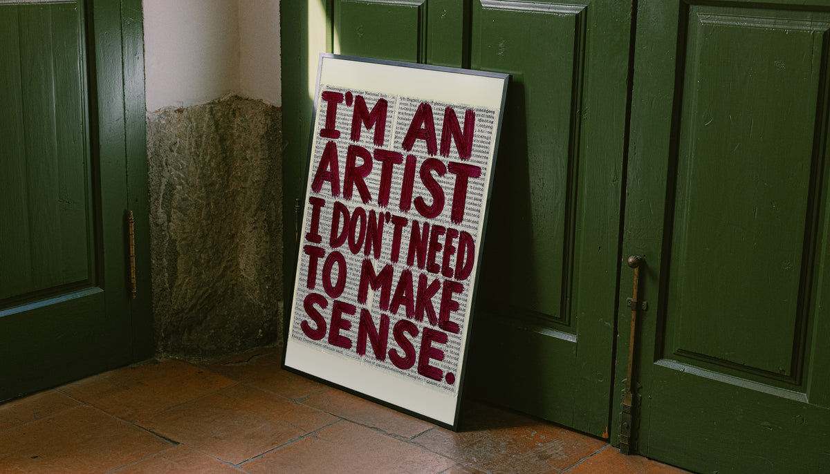 Freestanding framed newsprint quote poster with burgundy brush lettering on a light background