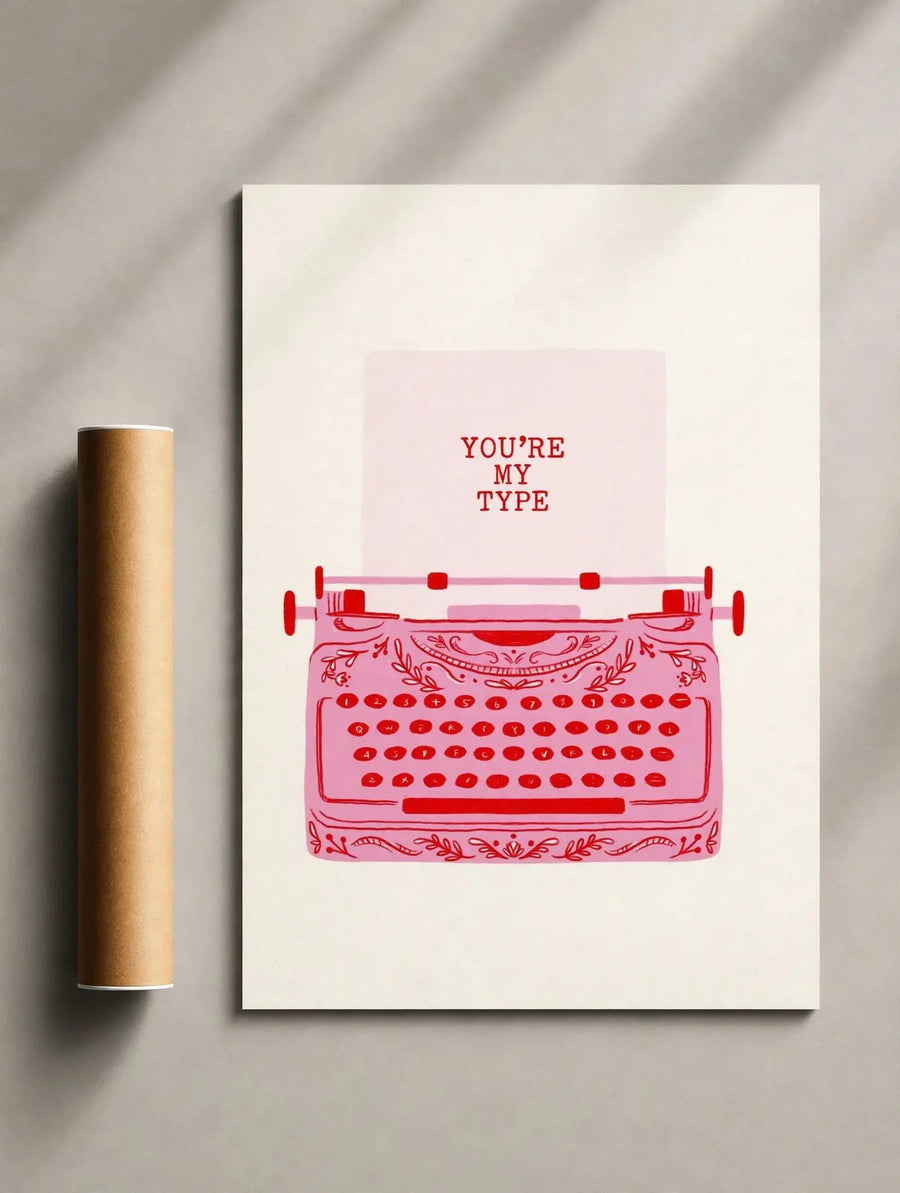Schreibmaschinen-Illustrationsprint im dunklen Rahmen mit roter Schreibmaschine und Schriftzug „YOU’RE MY TYPE“