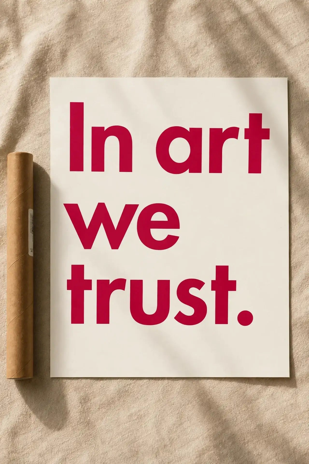 Typography wall print with red 'In art we trust.' text on off-white background.