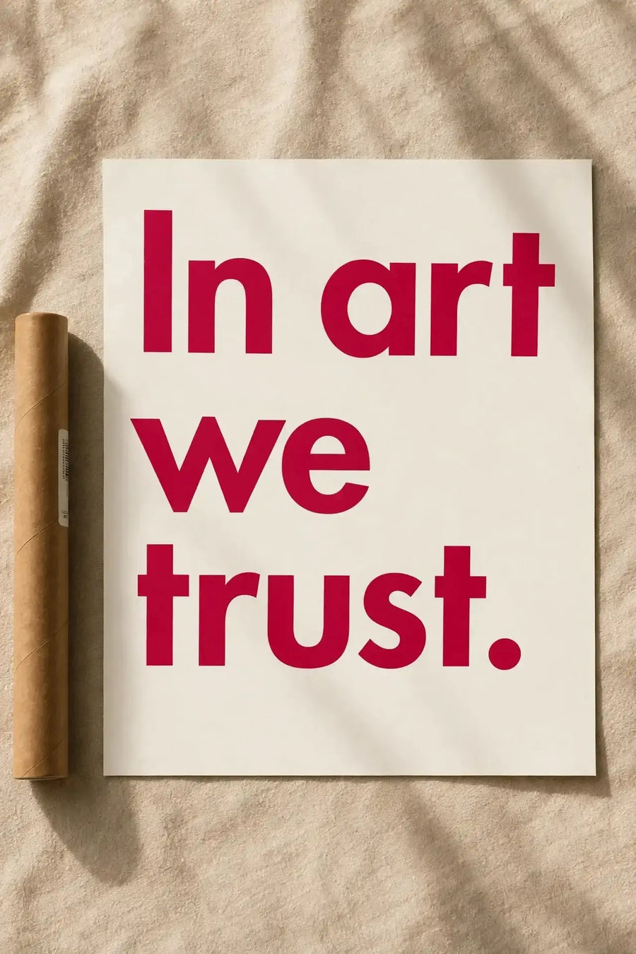 Typography wall print with red 'In art we trust.' text on off-white background.