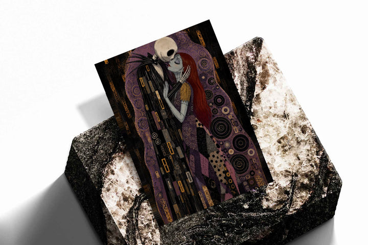 Jack Skellington and Sally embracing amid purple, black and gold ornamental patterns as an unframed print resting at an angle on a dark stone display