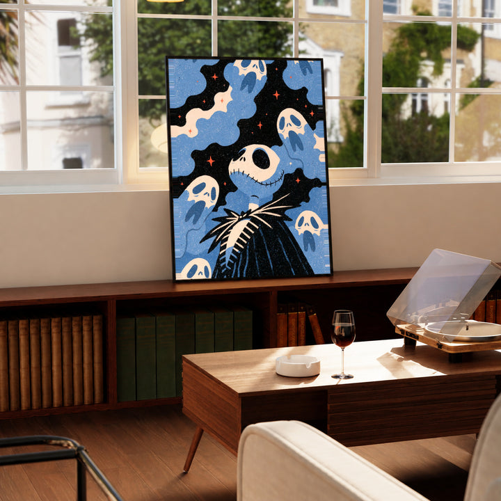 Jack Skellington surrounded by blue ghosts, cream clouds and tiny orange stars on black in a black display frame on a wooden console beside a sunlit window