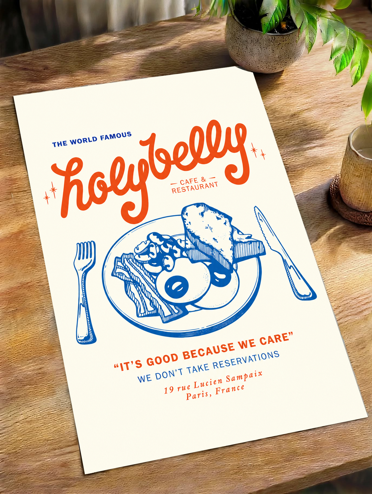 Ambientazione del poster senza cornice su un tavolo di legno alla luce naturale: Illustrazione della colazione Holybelly con grandi scritte rosse, piatto blu con uova e pane tostato, forchetta, coltello e testi da caffetteria su crema.