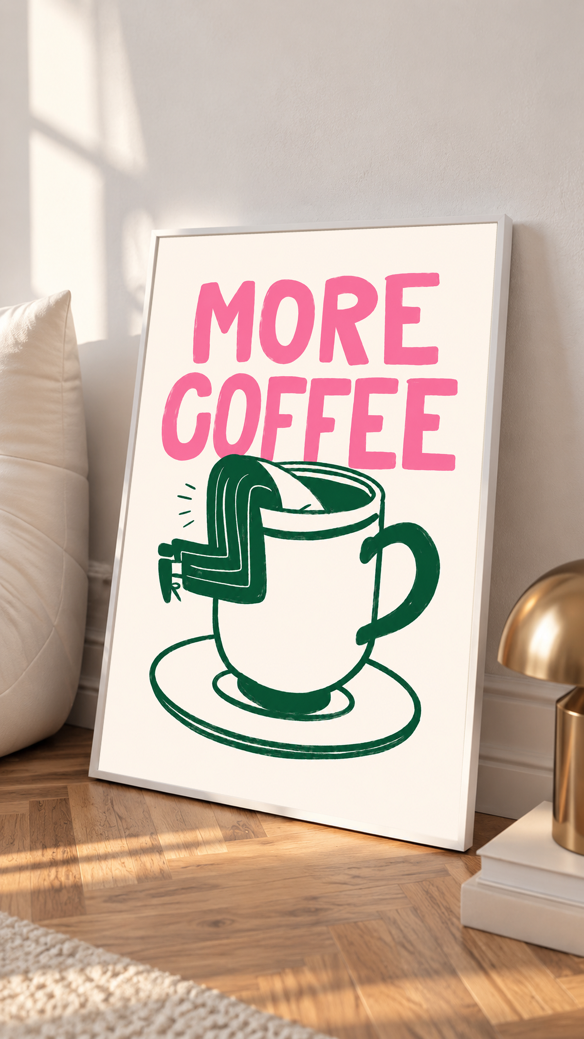 Mockup im weißen Rahmen, neben einem Kissen an eine helle Wand gelehnt: Großes rosa MORE COFFEE über einer grün gezeichneten Tasse mit Untertasse und einem Beinpaar über dem Rand auf Creme.