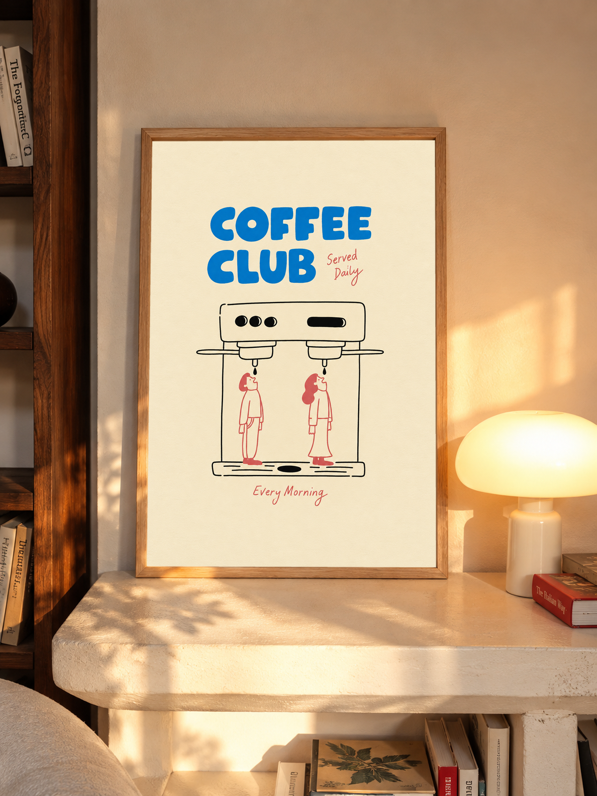 Blaues Coffee Club-Motiv mit schwarz gezeichneter Espressomaschine, zwei korallroten Figuren, roter Schrift und cremefarbenem Hintergrund. Im Eichenrahmen auf einem Schreibtisch neben einer leuchtenden Pilzleuchte.