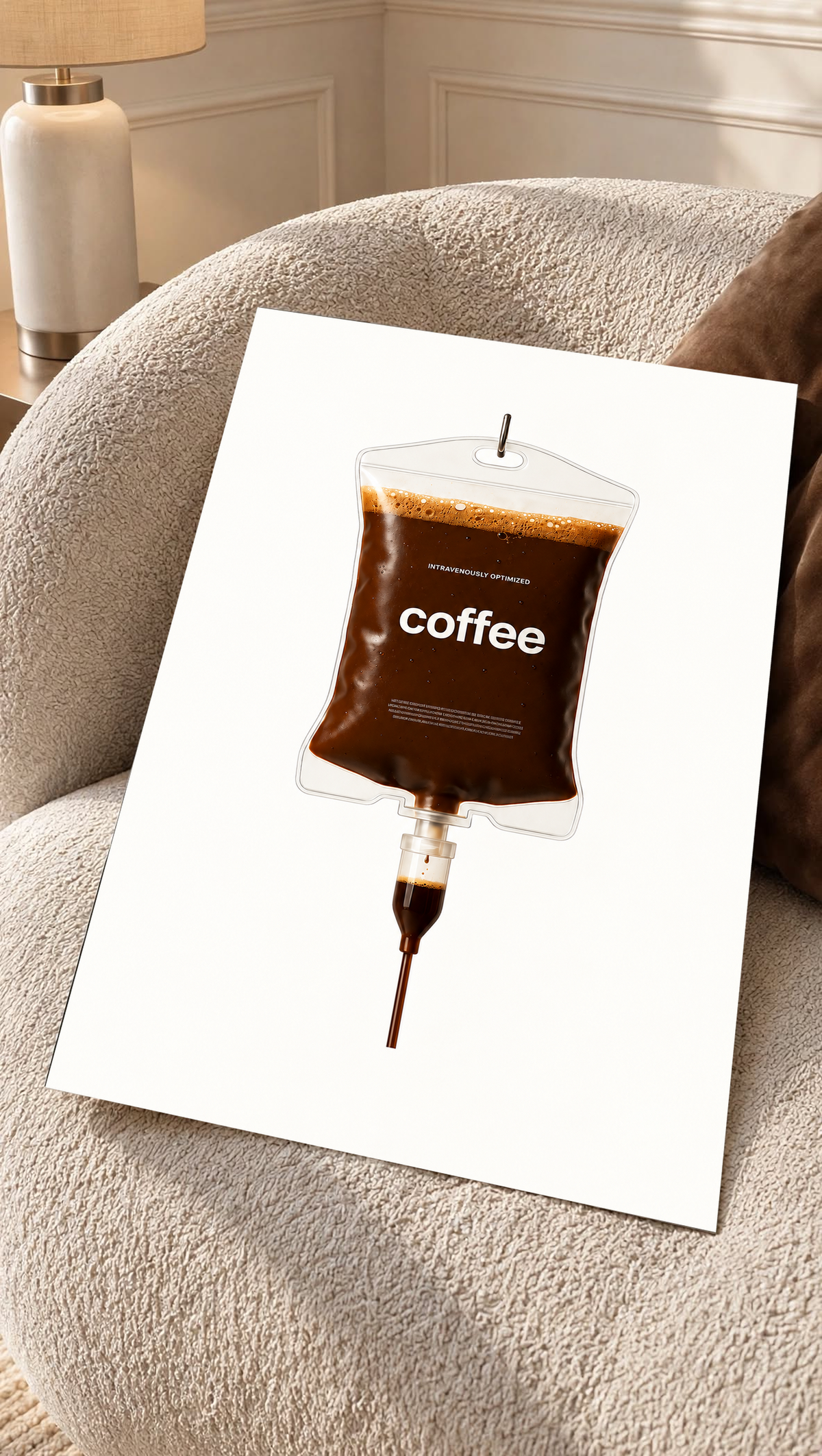 Ilustración surrealista Coffee IV con café marrón oscuro, burbujas de espuma dorada, bordes transparentes y etiqueta coffee sobre blanco. Póster sin marco sobre un sillón de textura color crema.