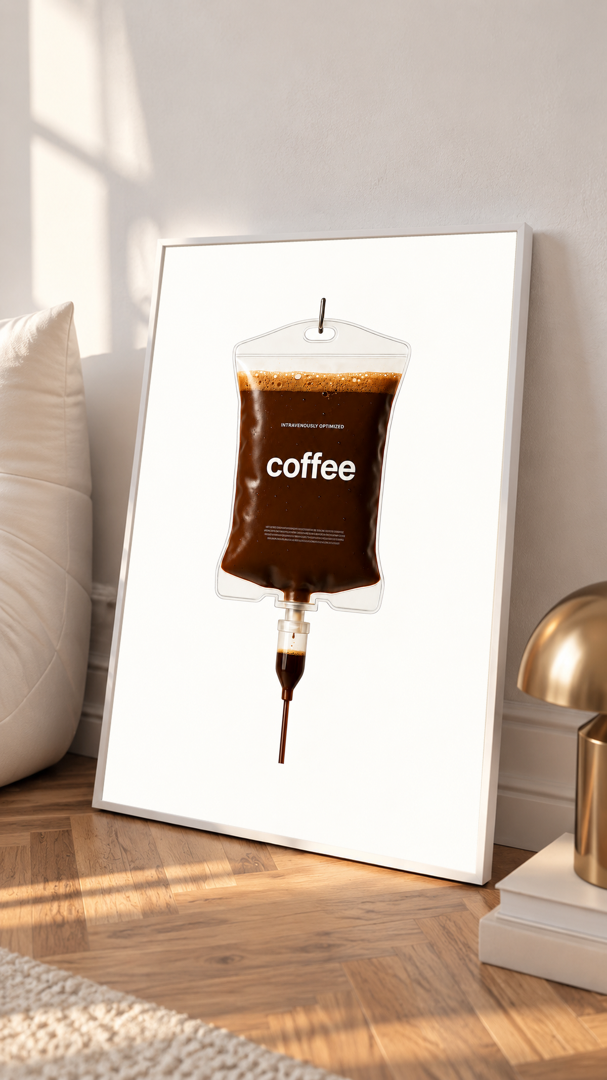 Ilustración surrealista Coffee IV con café marrón oscuro, burbujas de espuma dorada, bordes transparentes y etiqueta coffee sobre blanco. Con marco blanco apoyado en un suelo de madera junto a cojines y una lámpara pequeña.