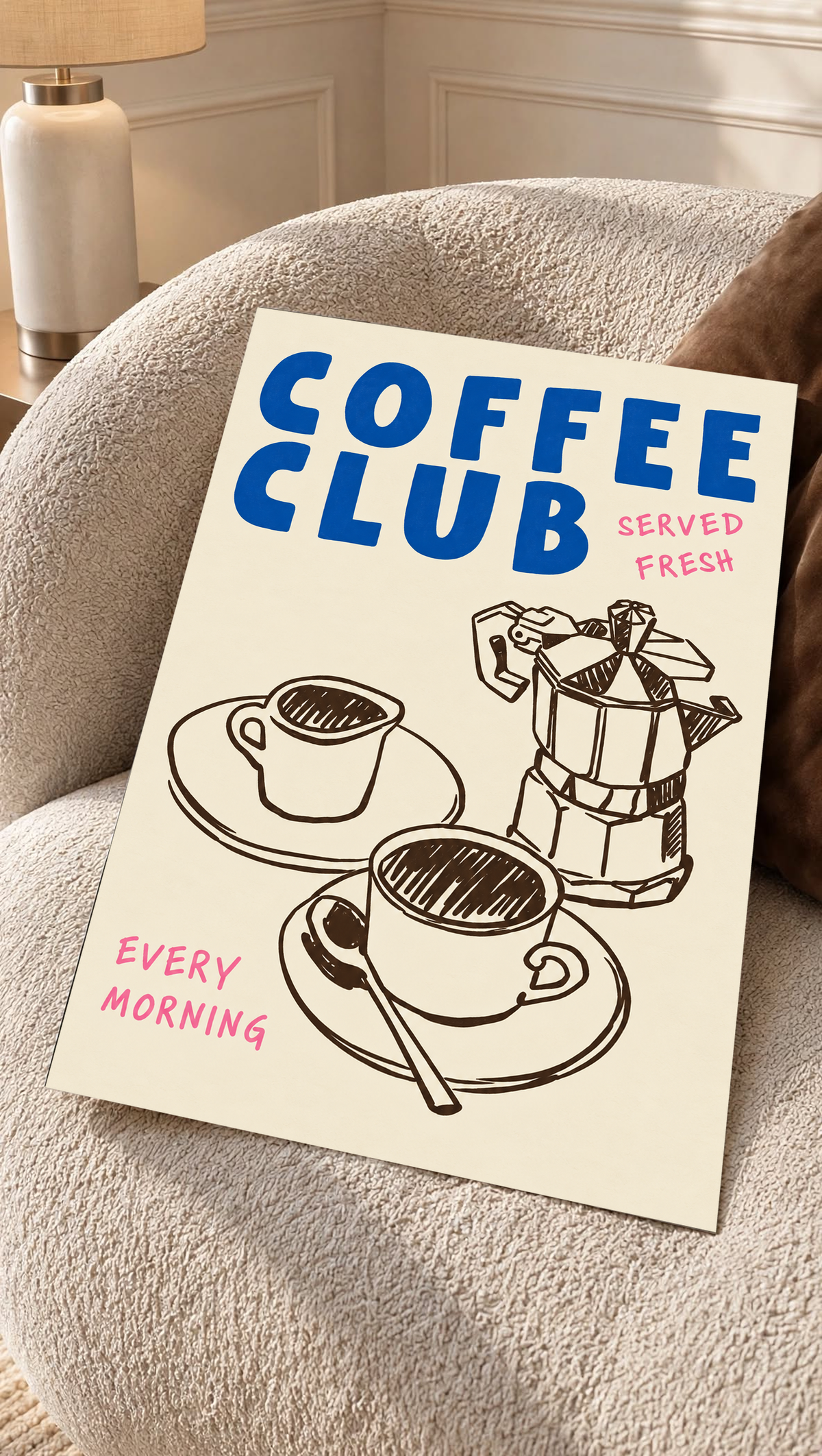 Blauer Schriftzug „Coffee Club“ mit rosa „Served Fresh“ und „Every Morning“ über einer braunen Mokkakanne und zwei Tassen auf Creme, als loses Poster auf einem cremefarbenen Sessel mit strukturierter Oberfläche.