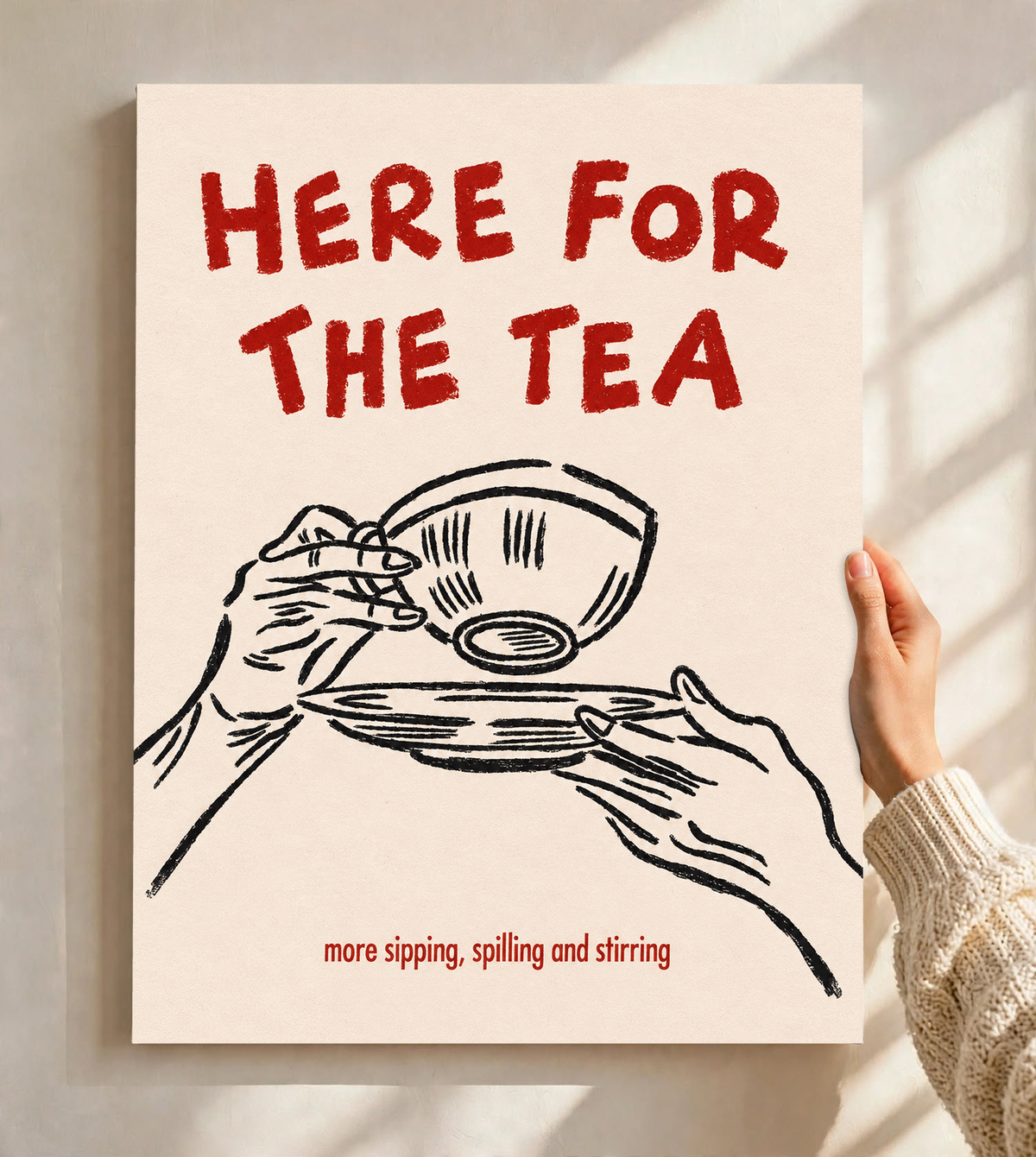 Roter Schriftzug „Here for the Tea“ über schwarz gezeichneten Händen mit Teetasse und Untertasse; darunter „more sipping, spilling and stirring“ auf Creme, als ungerahmtes Poster vor einer hellen Wand mit weichen Fensterschatten gehalten.