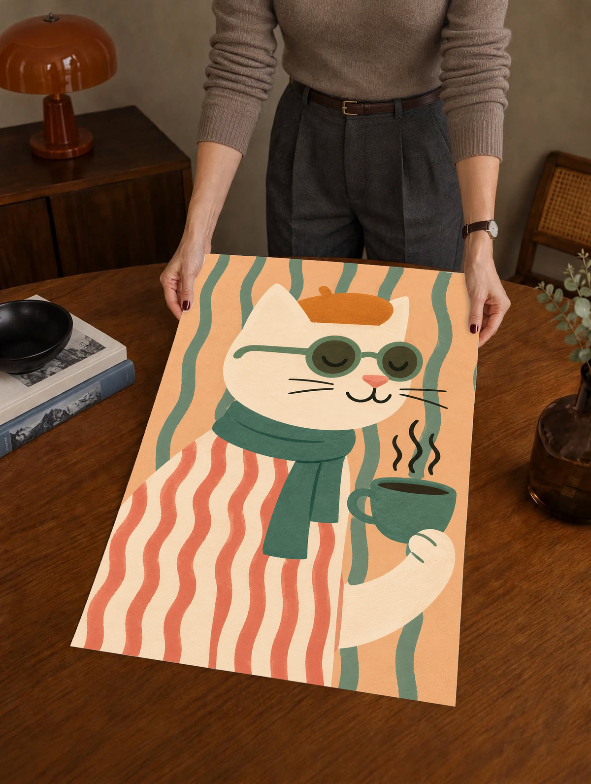Cat art print with a striped sweater, green scarf, and steaming mug, held by its edges