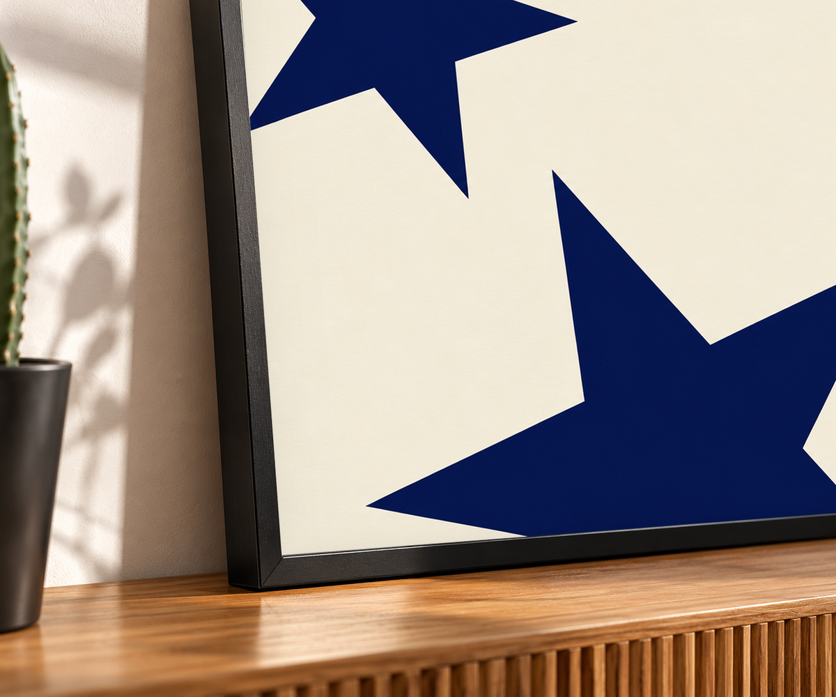Close-up of navy stars on cream art print in a black frame