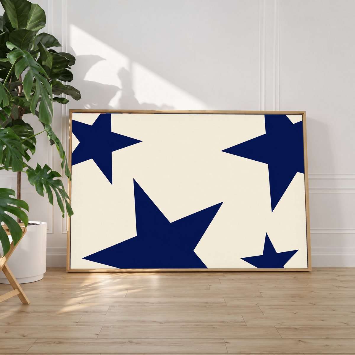 Cream art print with oversized navy stars in a slim oak frame
