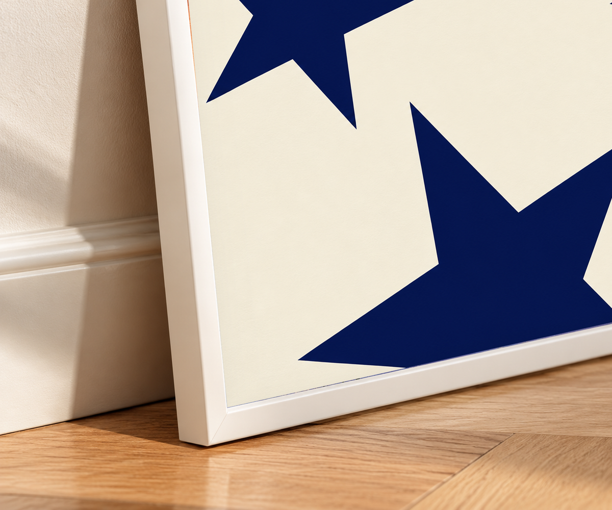 Close-up of navy star art print in a white frame