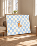 Un pequeño gato naranja con antifaz azul claro se sienta entre estrellas doradas sobre un tablero azul y crema. Marco de aspecto roble junto a una butaca clara y ventanas altas con luz natural cálida.