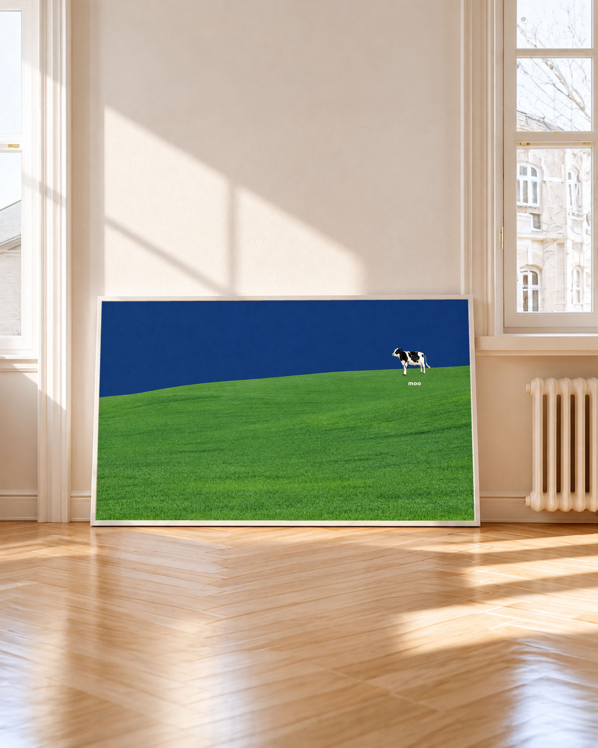 Una pequeña vaca blanca y negra se sitúa en una amplia colina verde bajo un cielo azul marino, con la palabra blanca moo debajo. Marco blanco junto a una ventana alta, con sol y sombras sobre el suelo de madera.