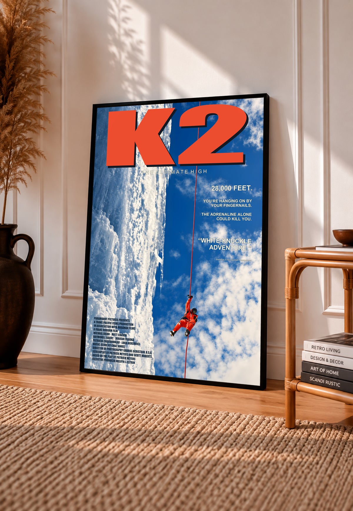 K2 mountaineering poster in a black frame, with a climber scaling a glacier