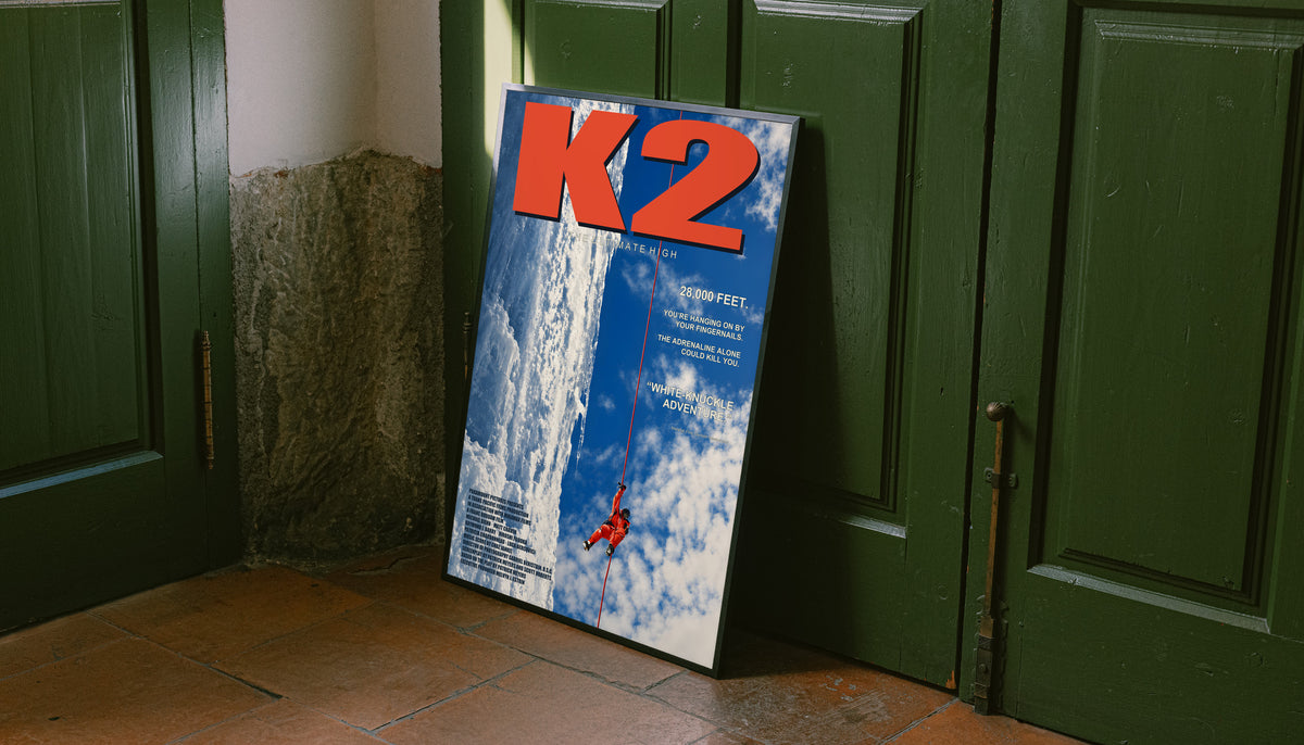 K2 mountaineering poster leaning upright, with a red climber on a glacier
