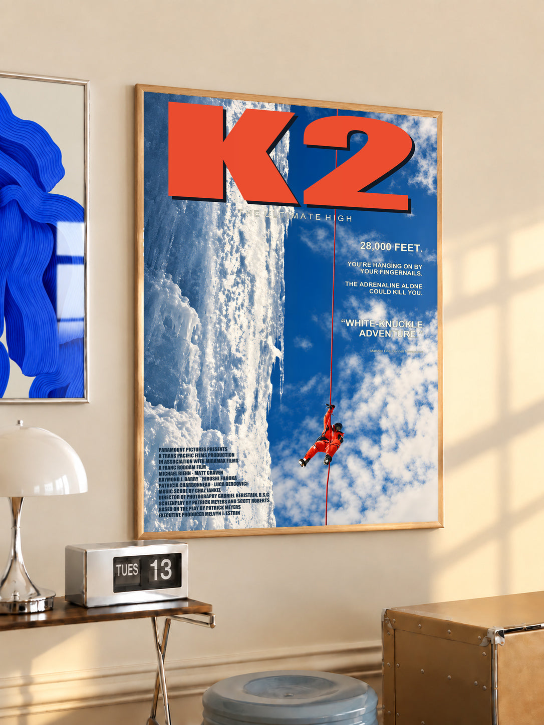 K2 mountaineering poster in a light wood frame, with a red climber