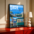 Green coastal train with blue sea and railway crossing in Kanagawa; black framed print on a red cabinet