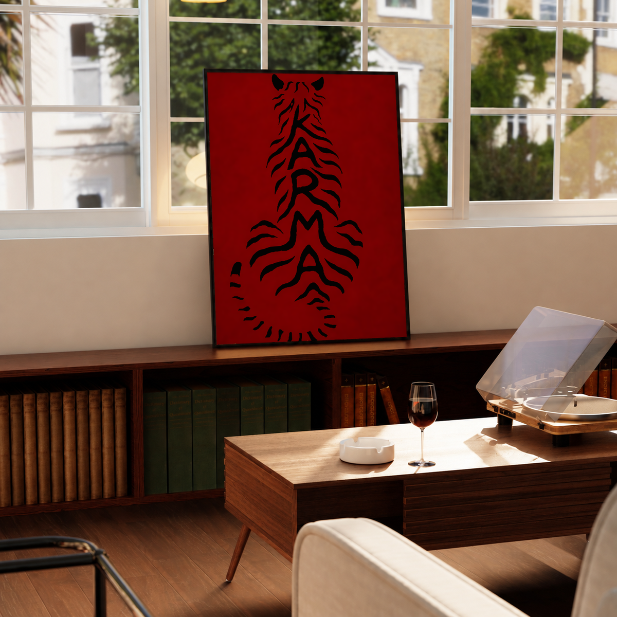 Framed deep red poster with black feline typography, displayed on a wooden sideboard.
