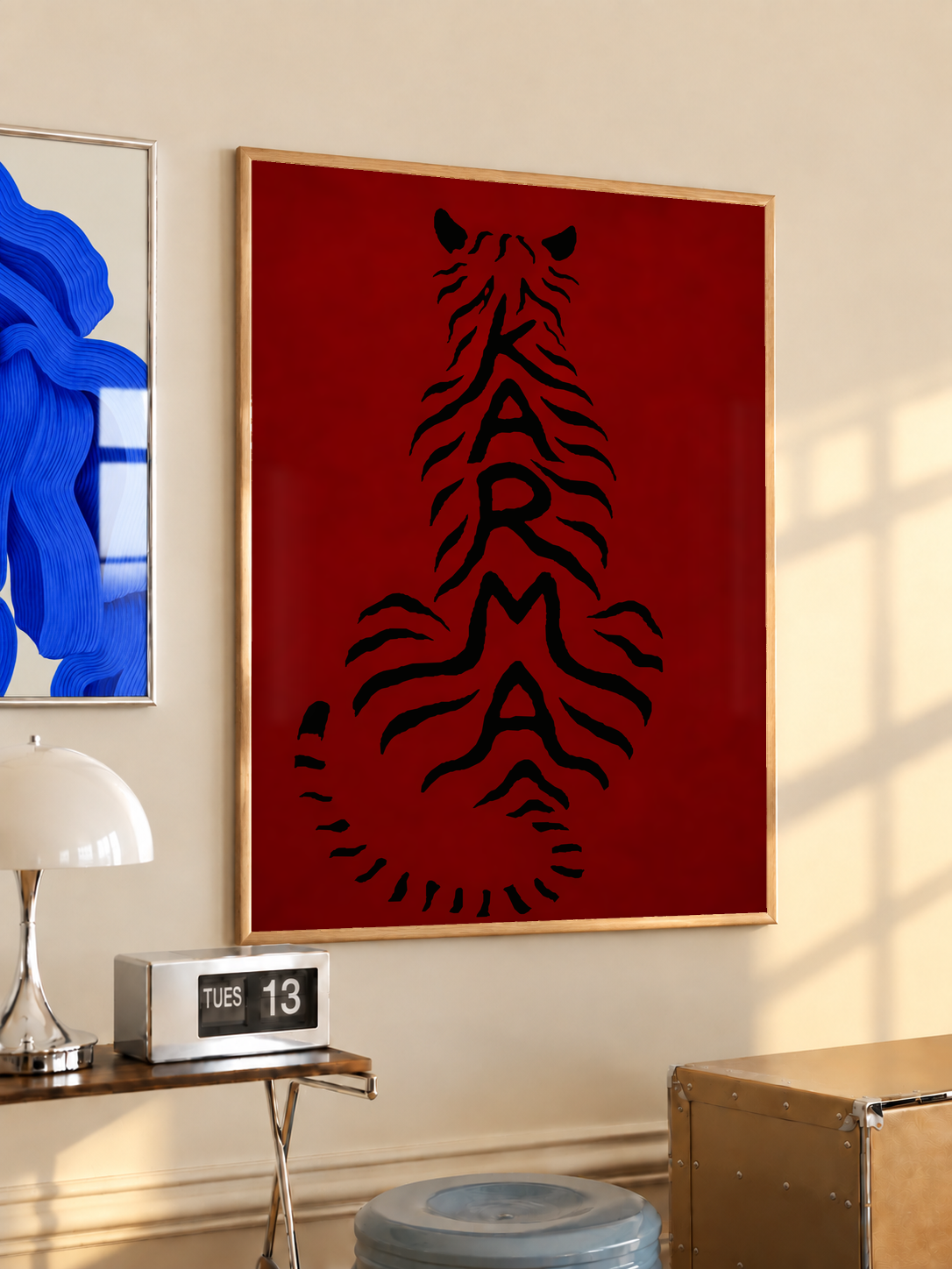 Gold-framed deep red poster with black feline typography, mounted on a wall.