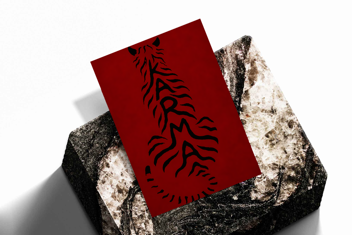 Deep red poster with black feline typography, angled on textured stone blocks.