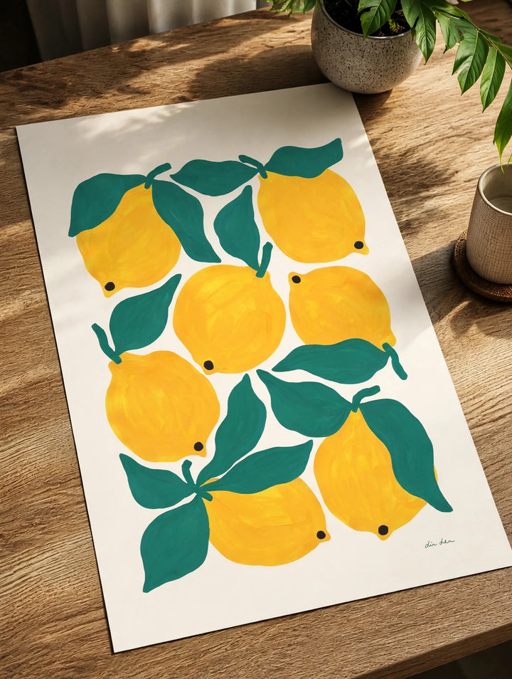 Lemon and green leaf art print on white paper lying on a wooden table