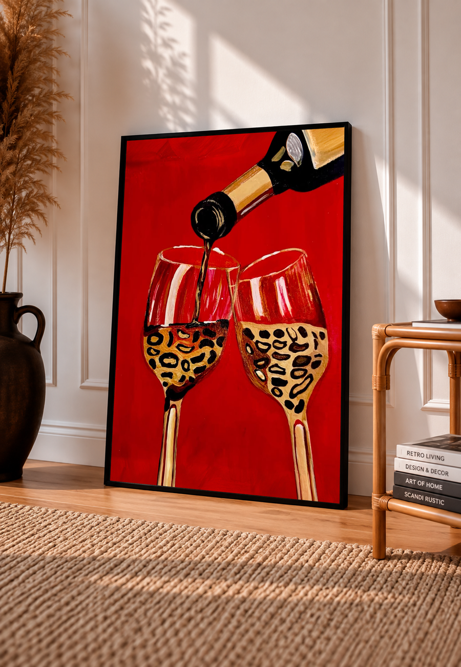 Framed wine poster showing bottle pouring into two leopard-print glasses on red