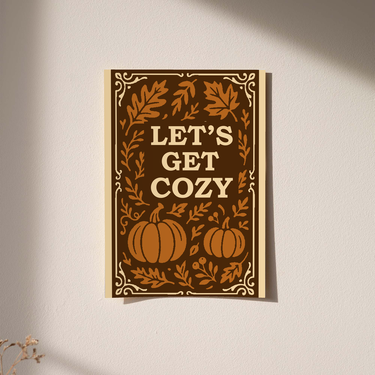 Framed wall poster with cream border showing brown pumpkins, leaves, and “Let’s Get Cozy”