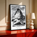 High-contrast black and white Matterhorn peak with bold caption and white border; black framed print on a red cabinet