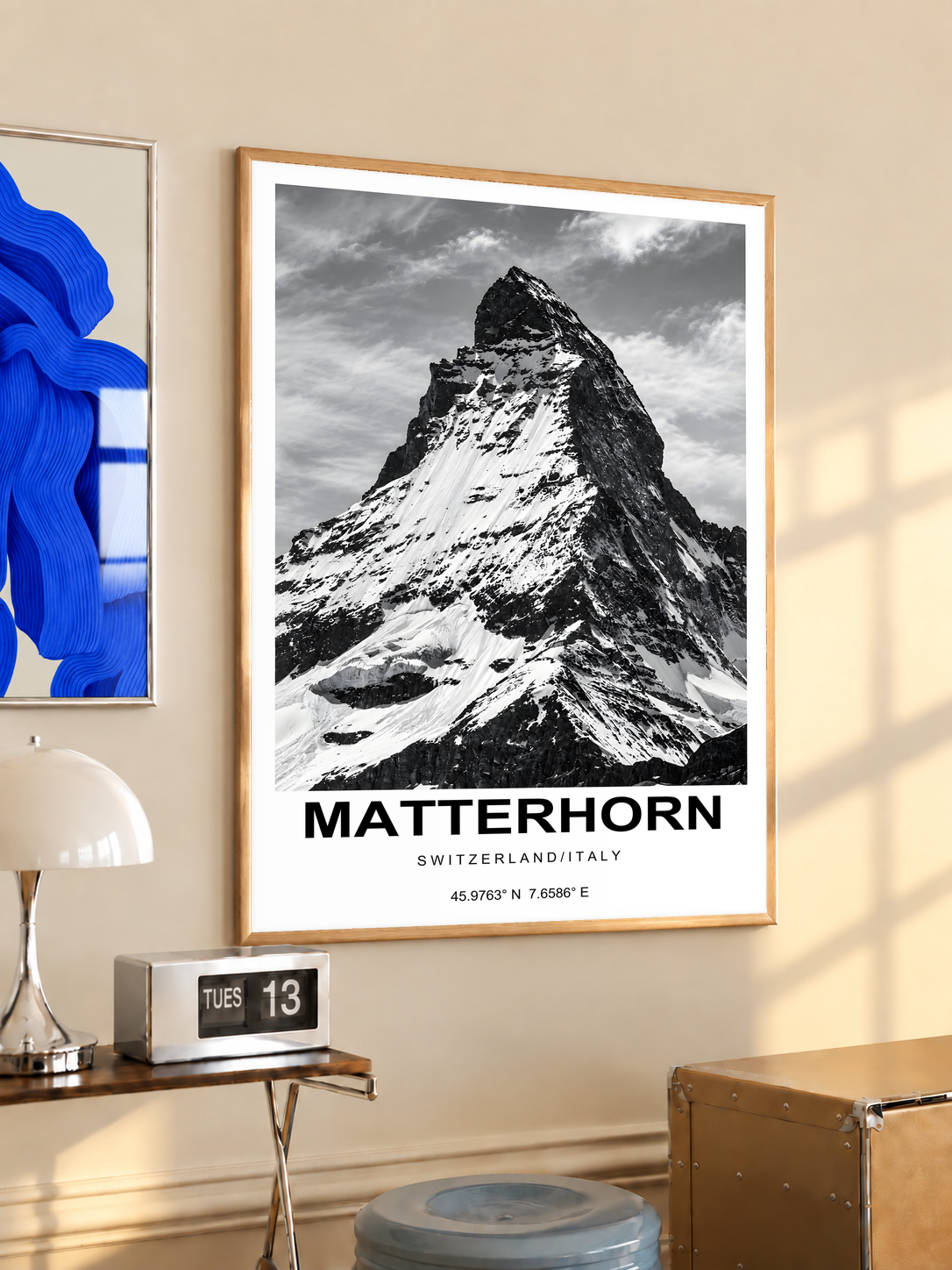 High-contrast black and white Matterhorn peak with bold caption and white border; oak framed print in a desk setting