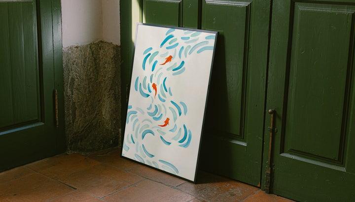 Small orange koi swimming among curved aqua and blue brushstrokes on cream leaning on the floor against dark green wall panelling